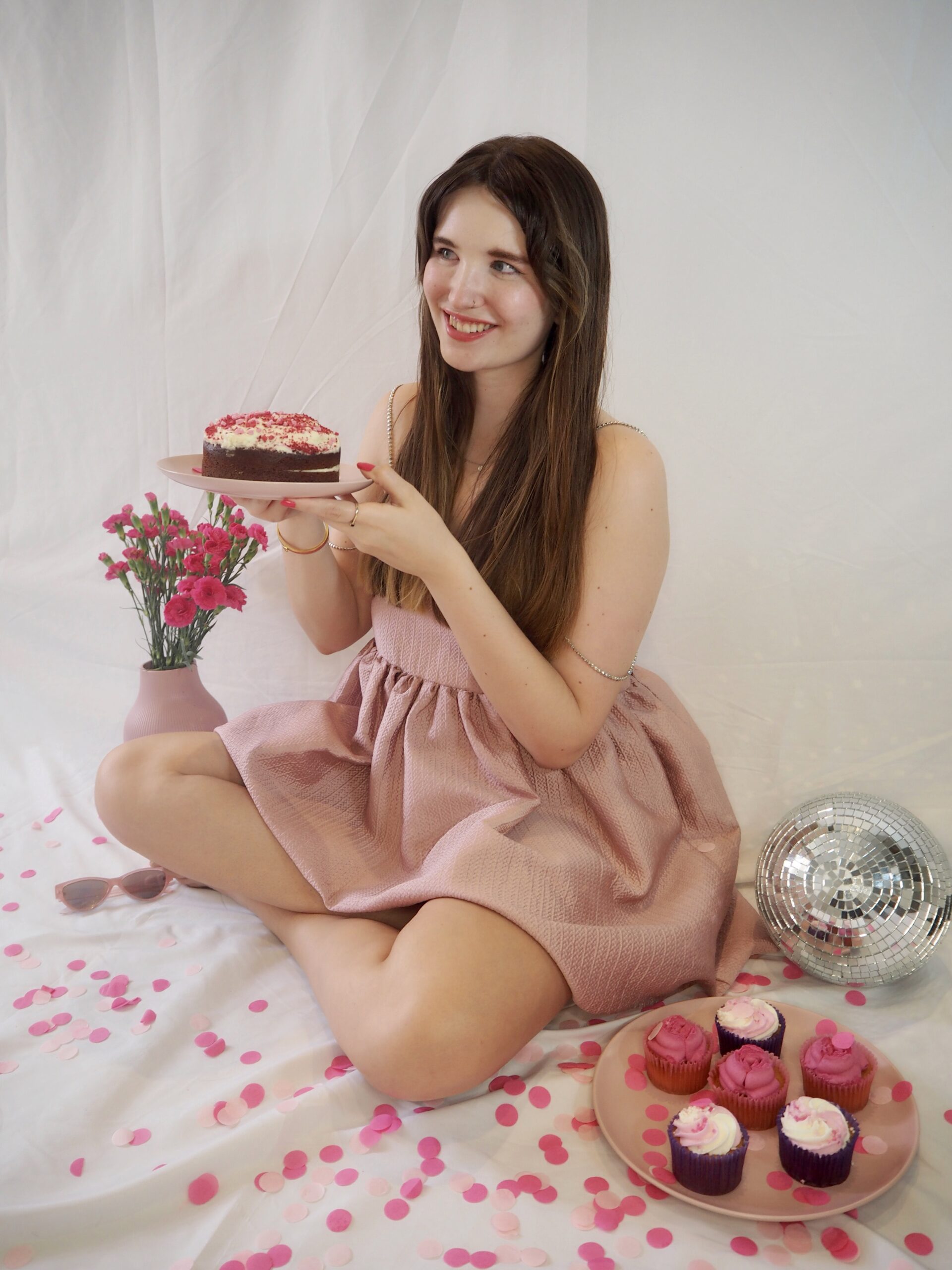 website copywriter for wedding pros wearing a pink dress and holding a pink cake